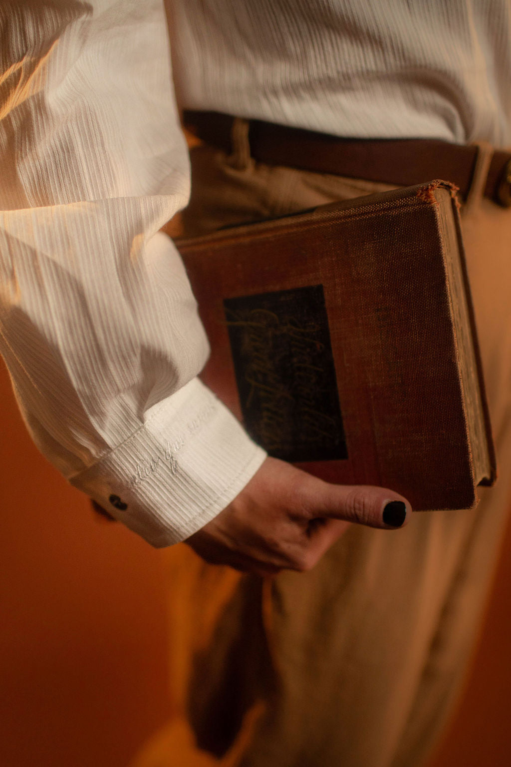 White cotton button up with a tone on tone stripe. Featuring wooden buttons and embroidered latin phrase on the back and cuffs translates to 'finding yourself in the whispers of the world'.