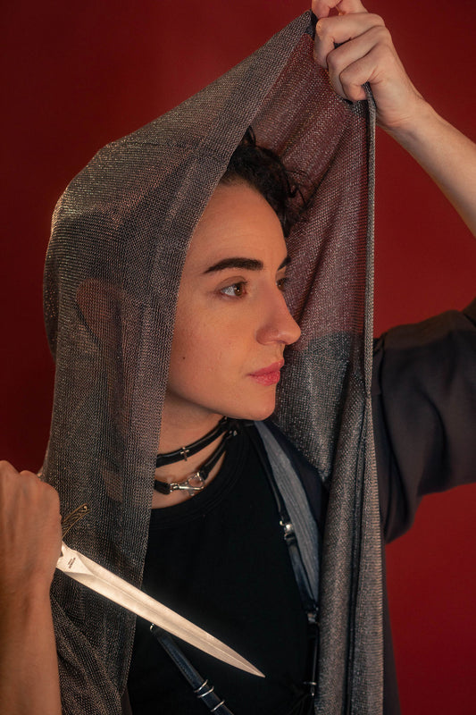 Silver hooded scarf made from a soft, knitted, renaissance faire - friendly fabric resembling chainmaille. Featured here with our Reliquary Robe wrap.