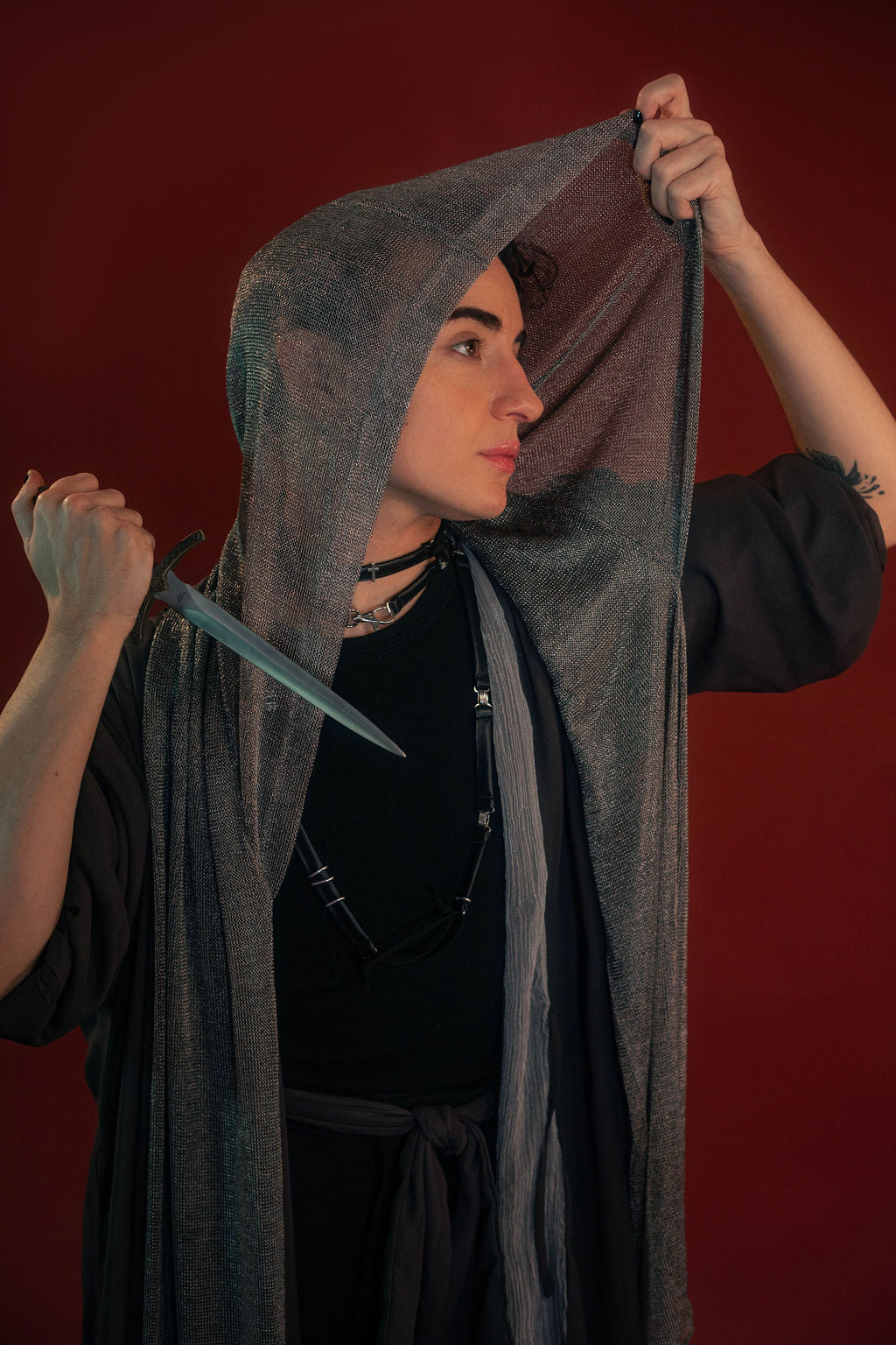 Silver hooded scarf made from a soft, knitted, renaissance faire - friendly fabric resembling chainmaille. Featured here with our Reliquary Robe wrap.