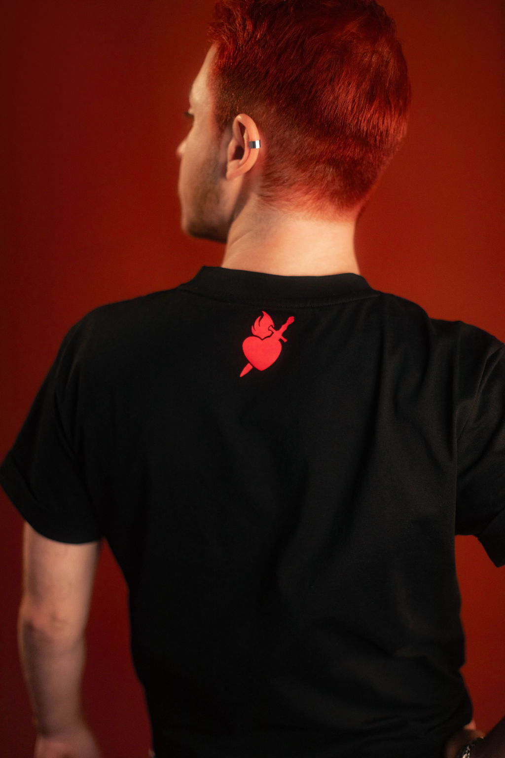 Black 100% cotton tshirt with embroidered red sword and heart design on chest, cuffed sleeves with a hand-tacked red X on one, printed collar information, and Saints & Sonnets heart and sword logo on a red hem tag and printed in red on the back collar.