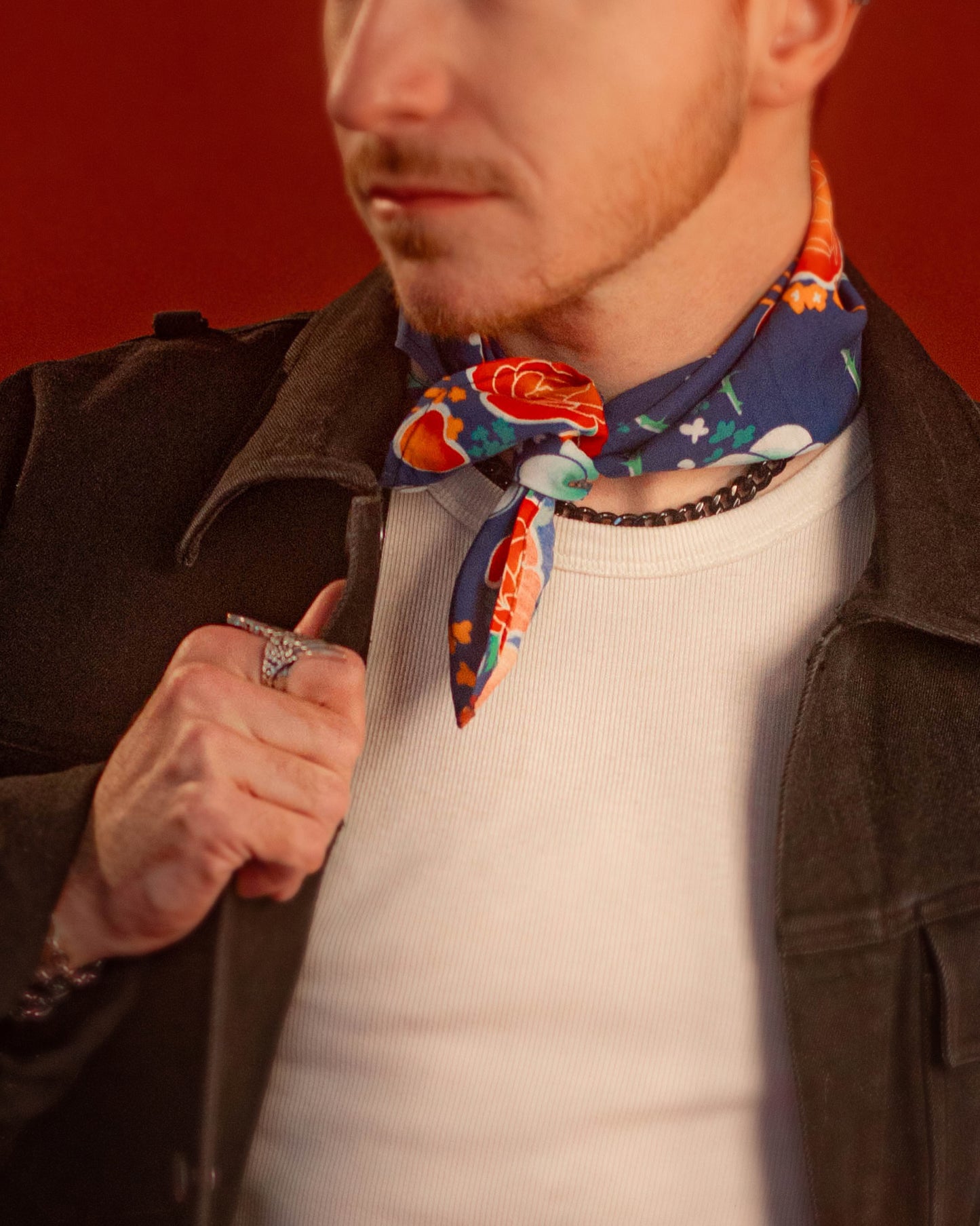 Blue, red, orange, and teal floral patterned rayon bandana accessory with a silky feel. Matches both pattern and fabric as our Montague Button Down Hawaiian-style shirt. Featured here as a pop of color on our Good Luck Jeanne denim Jacket.