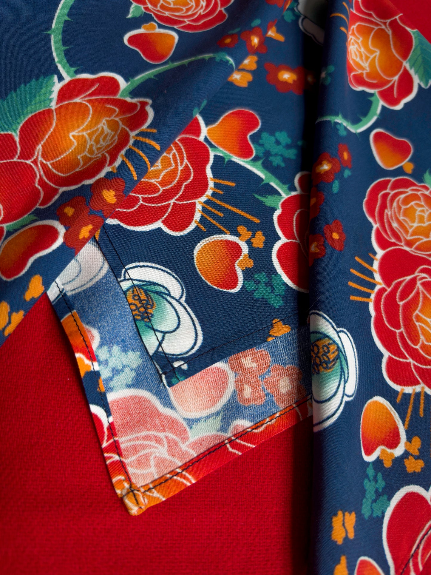 Blue, red, orange, and teal floral patterned rayon bandana accessory with a silky feel. Matches both pattern and fabric as our Montague Button Down Hawaiian-style shirt.