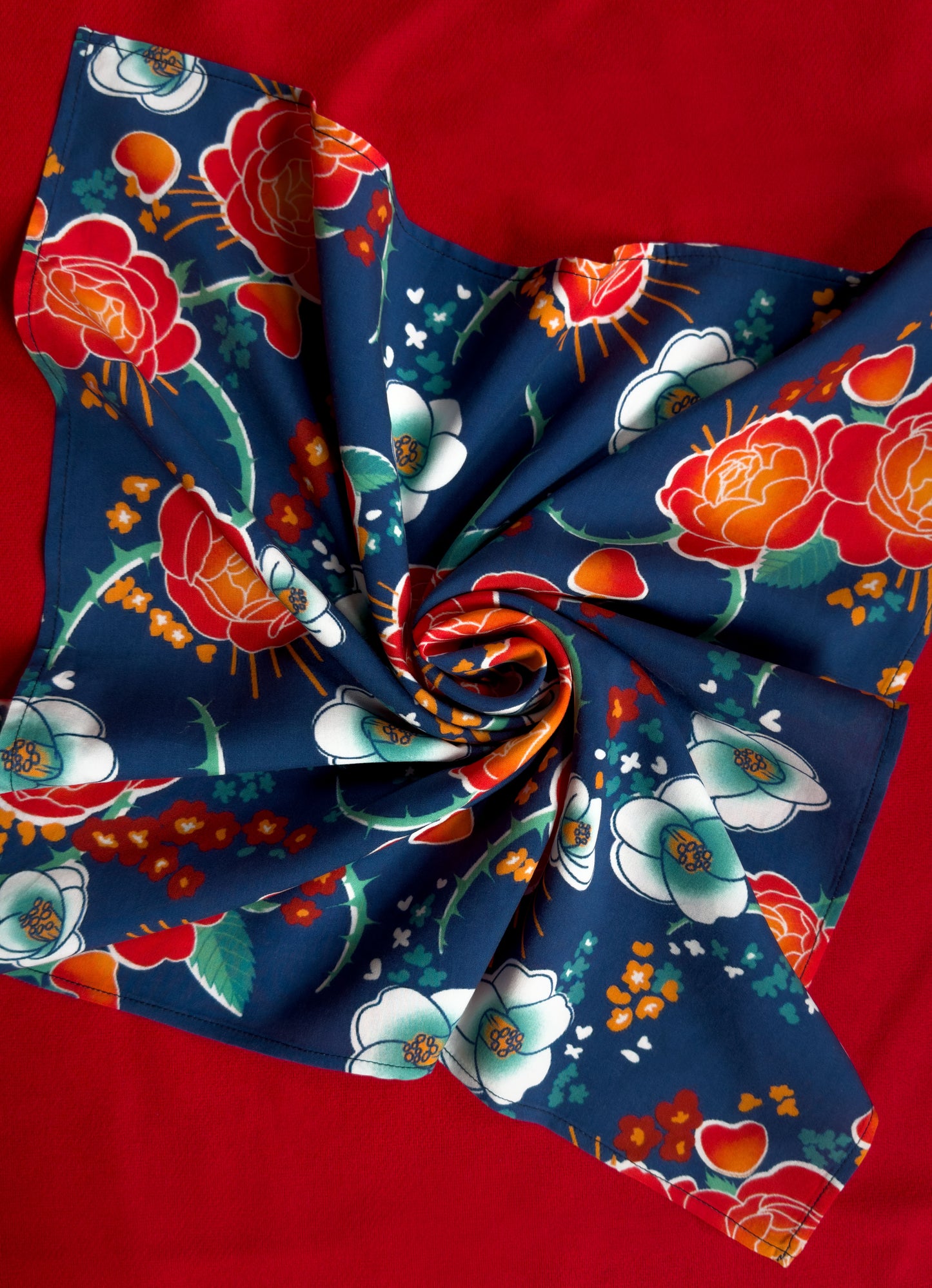 Blue, red, orange, and teal floral patterned rayon bandana accessory with a silky feel. Matches both pattern and fabric as our Montague Button Down Hawaiian-style shirt.