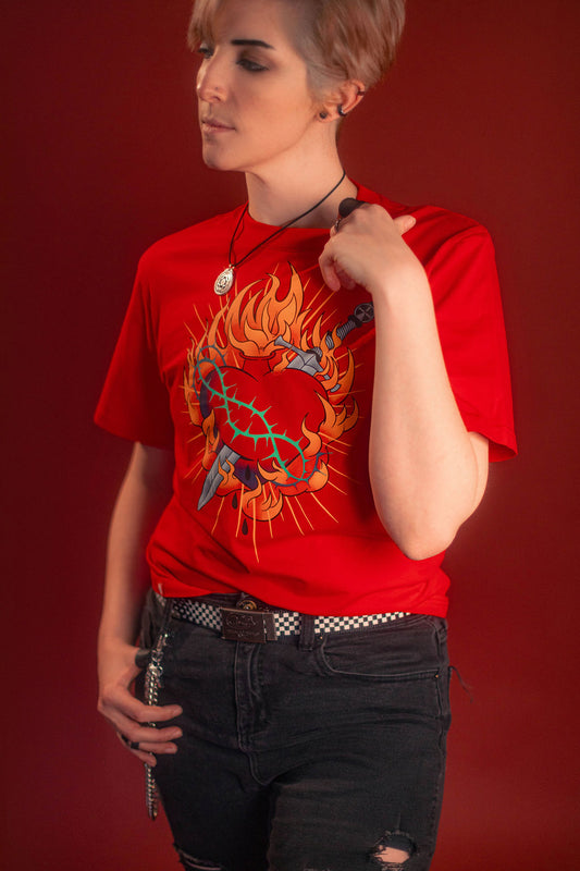 Fire red cotton tshirt with a full-color print on the front featuring the custom yellow, orange, teal, and silver flaming heart graphic with dagger and thorns. Printed collar tag information, and Saints & Sonnets logo hem tag.