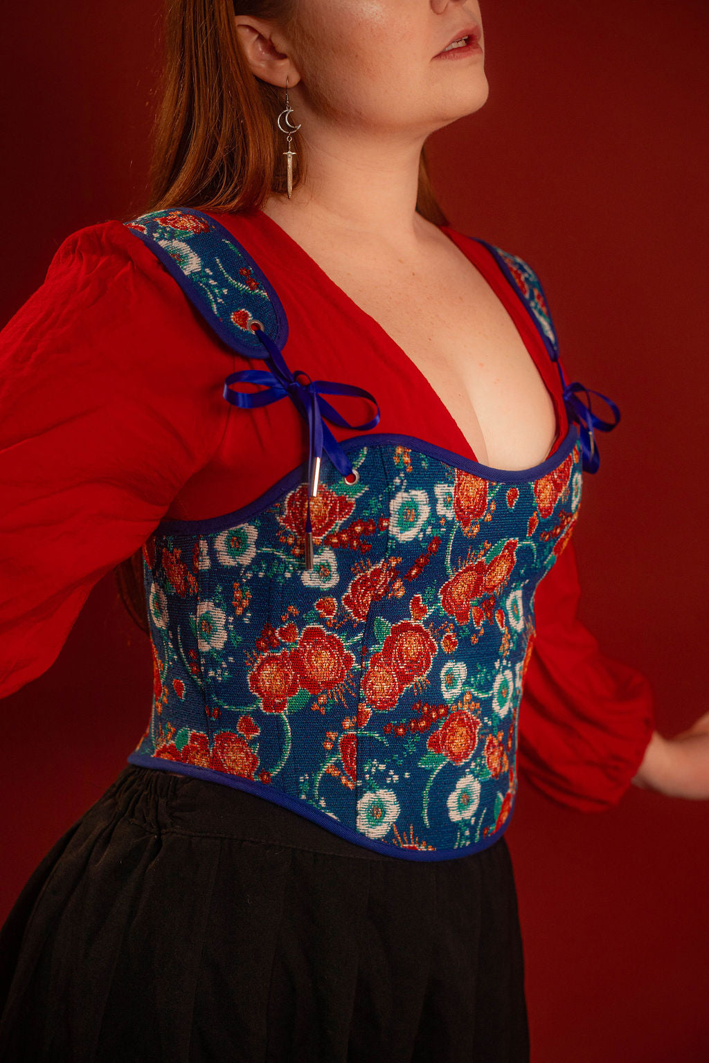 Reversible corset top with floral brocade matching our Montague button up and Lovers Favor bandana on one side and a cobalt blue cotton twill on the other with a printed red, orange, yellow, teal, and silver sacred heart in the middle. Nylon boning for shape, red and blue pairs of satin ribbon to tie removable straps and lace up the back. 