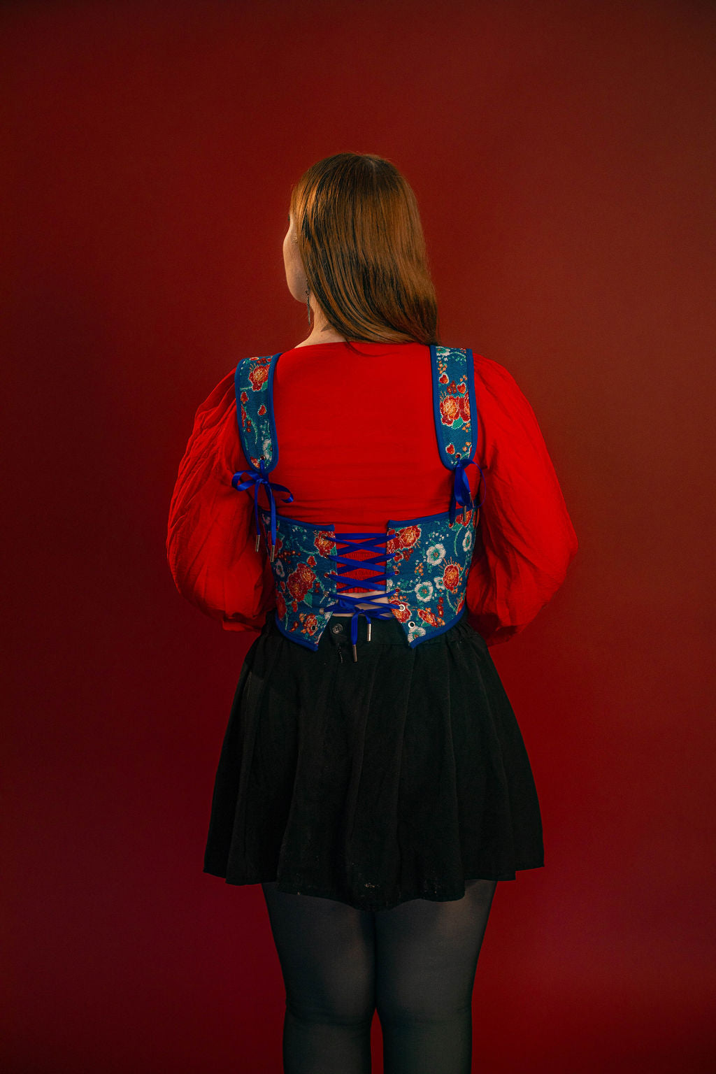 Reversible corset top with floral brocade matching our Montague button up and Lovers Favor bandana on one side and a cobalt blue cotton twill on the other with a printed red, orange, yellow, teal, and silver sacred heart in the middle. Nylon boning for shape, red and blue pairs of satin ribbon to tie removable straps and lace up the back. 