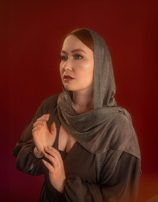 Silver hooded scarf made from a soft, knitted, renaissance faire - friendly fabric resembling chainmaille. Featured here with our Reliquary Robe wrap.