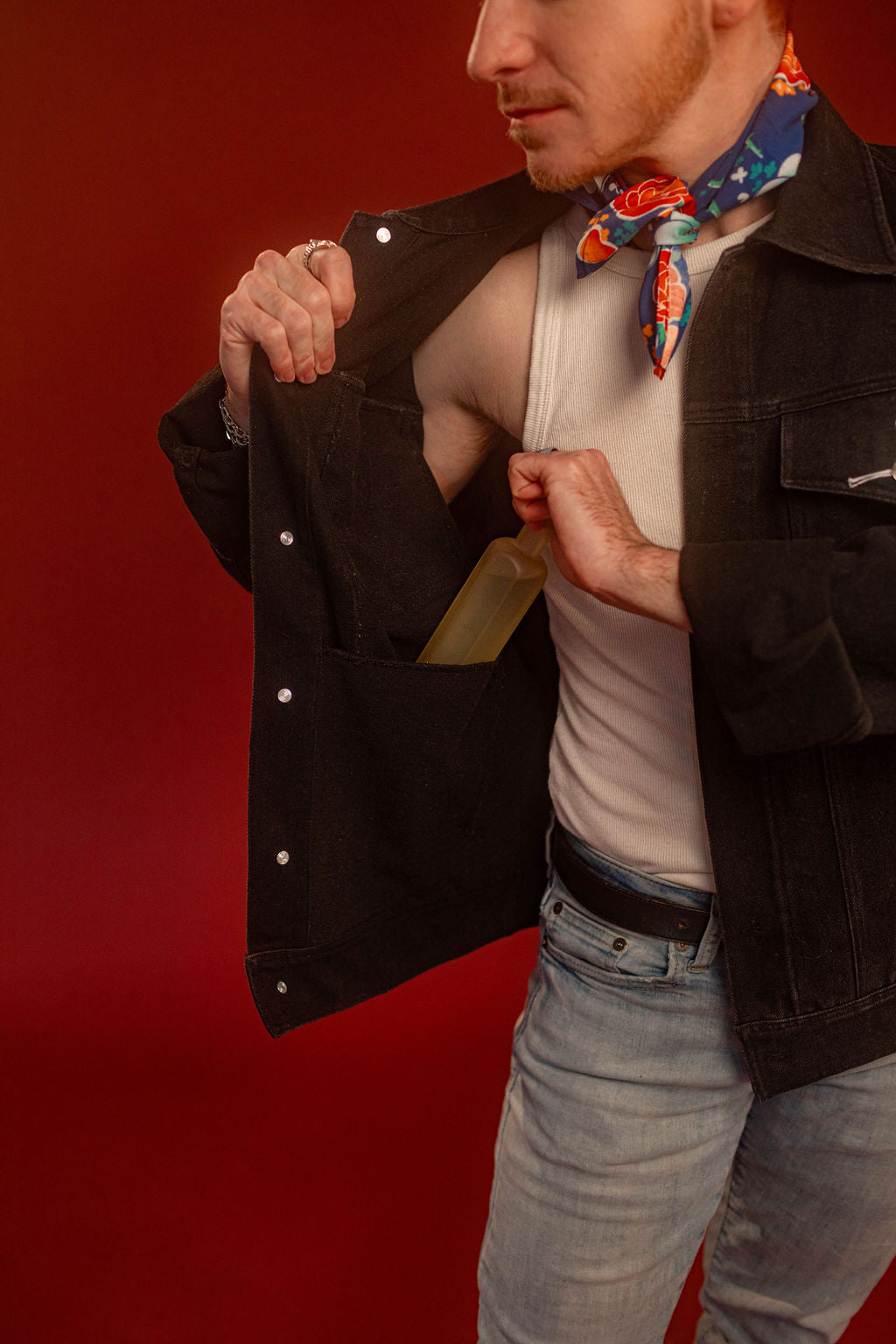 Black sturdy cotton denim jacket with white screen-printed sword on chest pocket and sacred heart graphic on a back patch. Custom pearl button on front pocket aligned with sword's pommel, five pockets, and multiple reinforced D rings for clipping accessories on to, like our Heart On Your Pocket Chain. Shown here with our Lovers Favor Bandana.