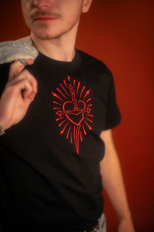 Black 100% cotton tshirt with embroidered red sword and heart design on chest, cuffed sleeves with a hand-tacked red X on one, printed collar information, and Saints & Sonnets heart and sword logo on a red hem tag and printed in red on the back collar.