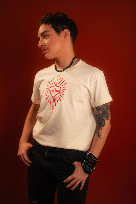 Off-white 100% cotton tshirt with embroidered red sword and heart design on chest, cuffed sleeves with a hand-tacked red X on one, printed collar information, and Saints & Sonnets heart and sword logo on a red hem tag and printed in red on the back collar.