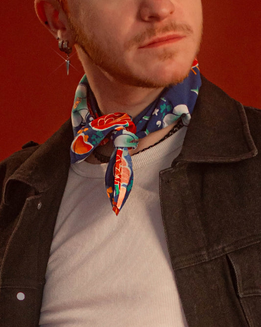 Blue, red, orange, and teal floral patterned rayon bandana accessory with a silky feel. Matches both pattern and fabric as our Montague Button Down Hawaiian-style shirt. Featured here as a pop of color on our Good Luck Jeanne denim Jacket.