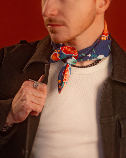 Blue, red, orange, and teal floral patterned rayon bandana accessory with a silky feel. Matches both pattern and fabric as our Montague Button Down Hawaiian-style shirt. Featured here as a pop of color on our Good Luck Jeanne denim Jacket.