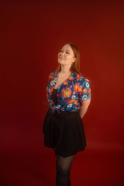 Red, orange, yellow, teal, and blue floral patterned hawaiian style shirt. 100% rayon for a silky feel and drape. Sacred heart graphic with thorn and sword printed on front left chest, and camp style collar. Matches in print and fabric with our Lovers Favor Bandana.