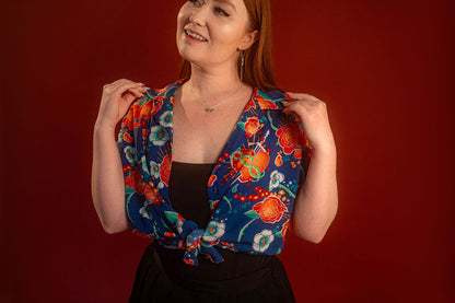 Red, orange, yellow, teal, and blue floral patterned hawaiian style shirt. 100% rayon for a silky feel and drape. Sacred heart graphic with thorn and sword printed on front left chest, and camp style collar. Matches in print and fabric with our Lovers Favor Bandana.