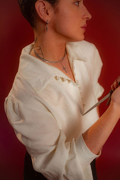 Soft, off-white tencel and linen blend to make the soft, flowy, draped shape of our poet shirt. Tone-on-tone embroidery on the collars, cuffs, and back yoke and buttons down the front and cuffs.