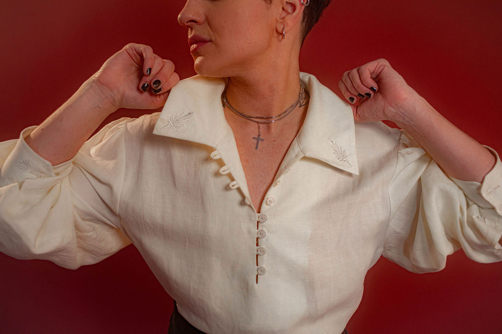 Soft, off-white tencel and linen blend to make the soft, flowy, draped shape of our poet shirt. Tone-on-tone embroidery on the collars, cuffs, and back yoke and buttons down the front and cuffs.