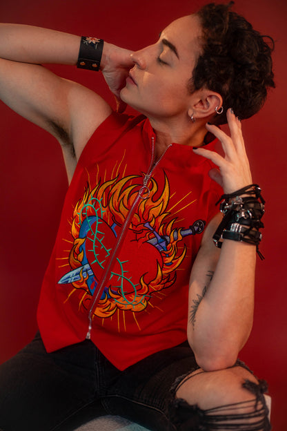Vibrant red cotton twill vest with zipper front closure and O ring silver zipper. Large, full color orange, yellow, teal, blue, and silver embroidered sacred heart design on chest. Grey and black checkered lining and inner pocket.